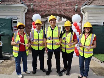 Cerritos City Council members pose with hammers while wearing hard hats and vests at the Heritage Park Play Island Renovation Project kickoff on March 30, 2026.
